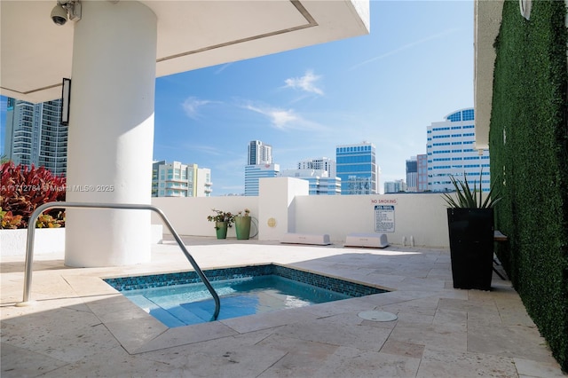 view of pool featuring a view of city, a patio area, and a hot tub