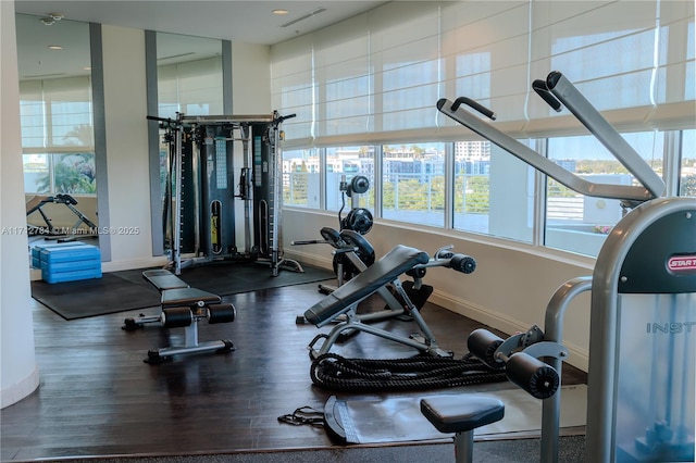 workout area featuring visible vents, baseboards, and wood finished floors