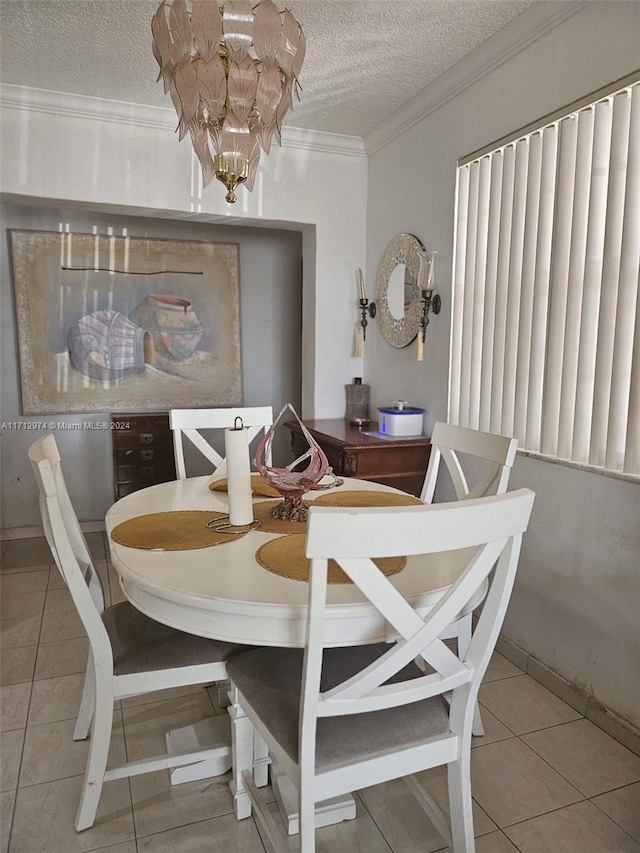 tiled dining area featuring an inviting chandelier, a textured ceiling, and ornamental molding