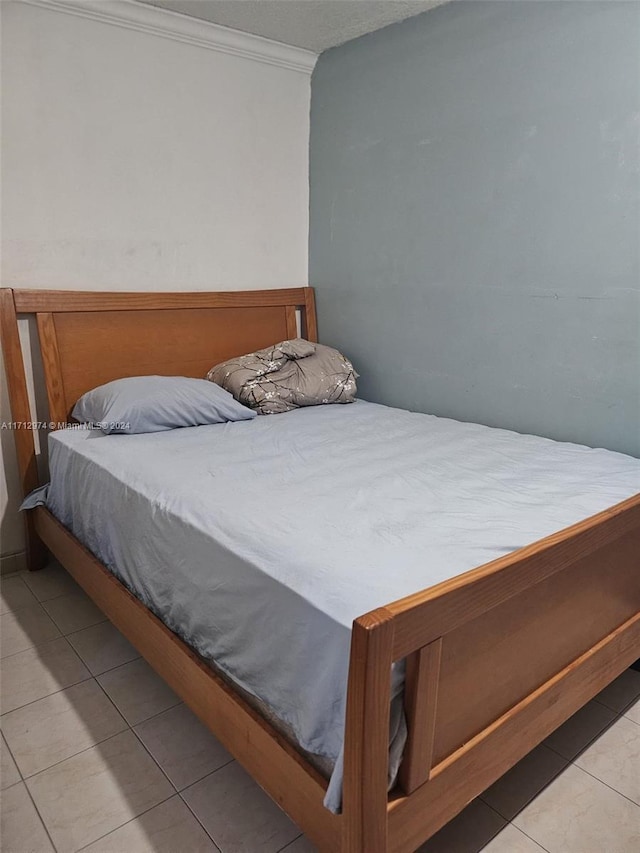 bedroom featuring light tile patterned floors and ornamental molding