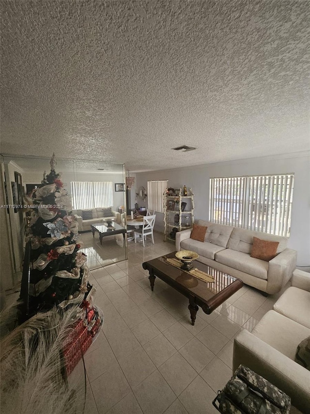 living room with a textured ceiling and light tile patterned flooring