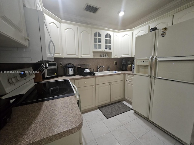 kitchen with stove, white refrigerator with ice dispenser, white cabinets, sink, and ornamental molding