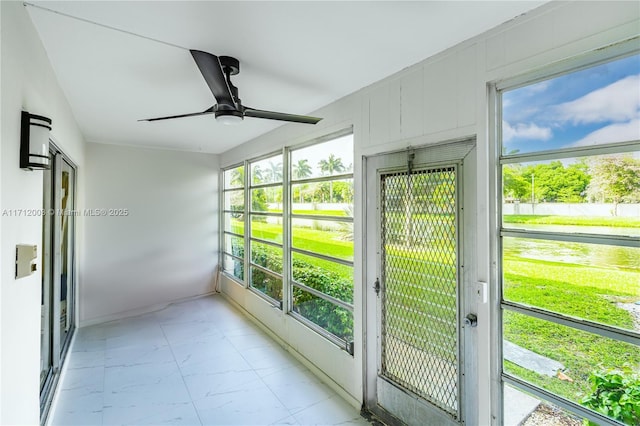 unfurnished sunroom with ceiling fan and a healthy amount of sunlight