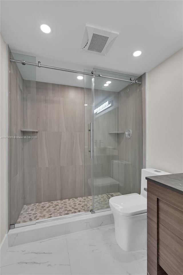 bathroom with vanity, toilet, and a shower with shower door