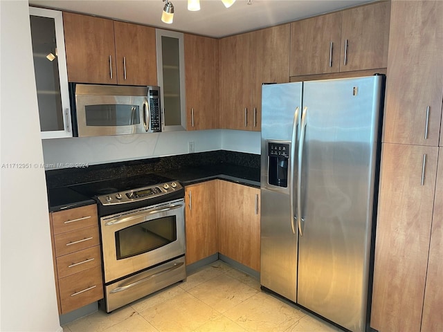 kitchen featuring stainless steel appliances and dark stone counters