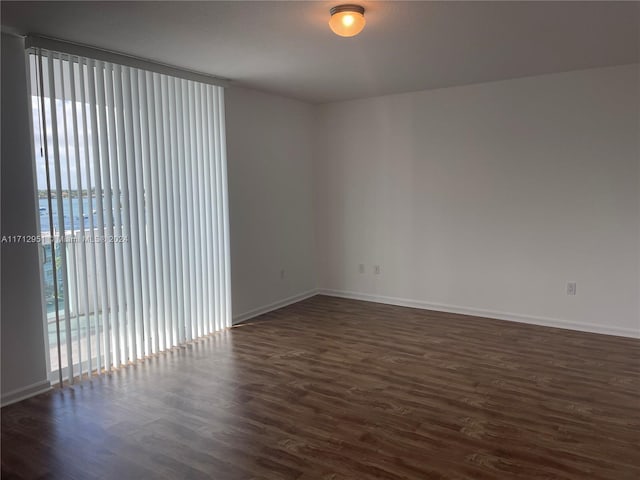 unfurnished room with dark hardwood / wood-style floors