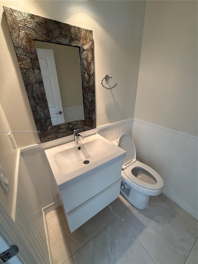 bathroom with tile patterned flooring, vanity, and toilet