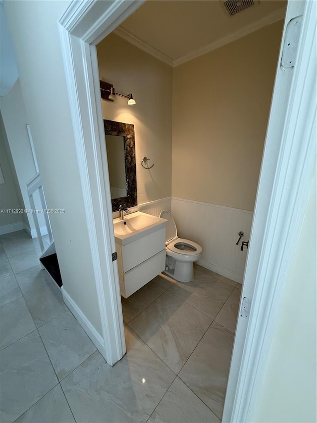 bathroom featuring vanity, ornamental molding, and toilet