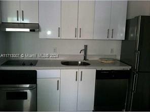 kitchen featuring white cabinets, sink, and black appliances