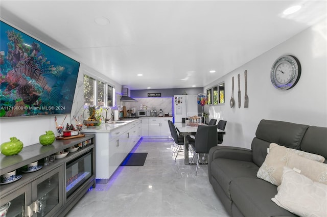 kitchen featuring white appliances, white cabinets, sink, wall chimney exhaust hood, and tasteful backsplash