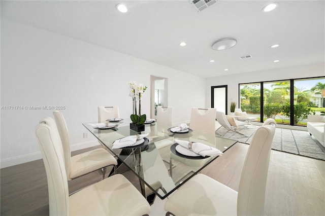 dining area featuring baseboards, visible vents, wood finished floors, and recessed lighting