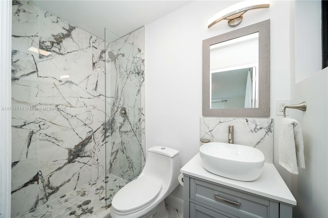 full bath featuring vanity, a marble finish shower, toilet, and decorative backsplash