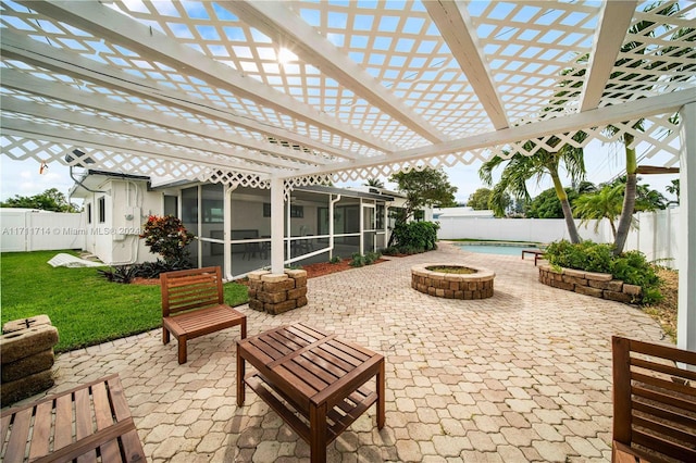 view of patio with a sunroom and an outdoor fire pit