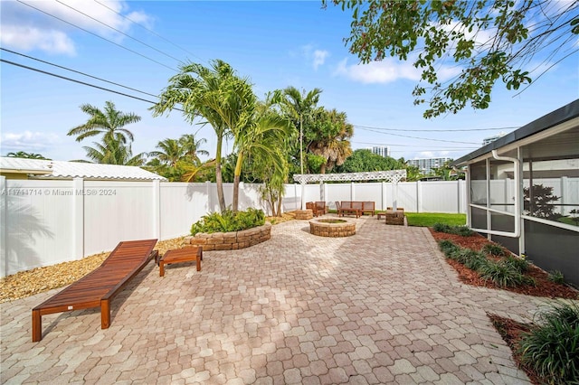 view of patio / terrace with a sunroom and an outdoor fire pit