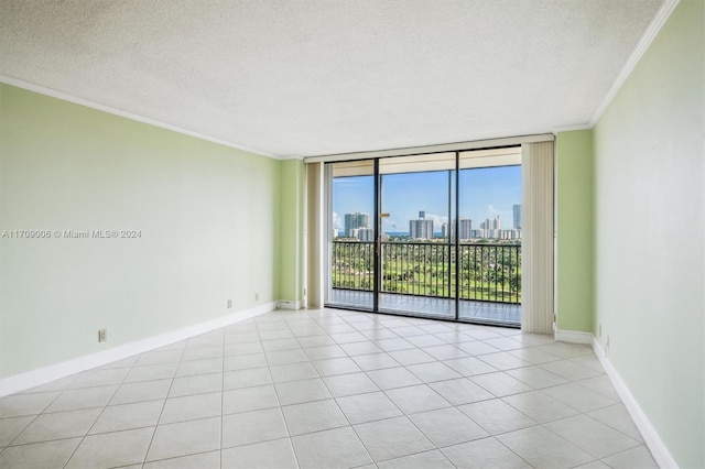 spare room featuring expansive windows, ornamental molding, a textured ceiling, and light tile patterned floors