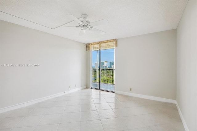 unfurnished room featuring light tile patterned floors, a textured ceiling, and ceiling fan