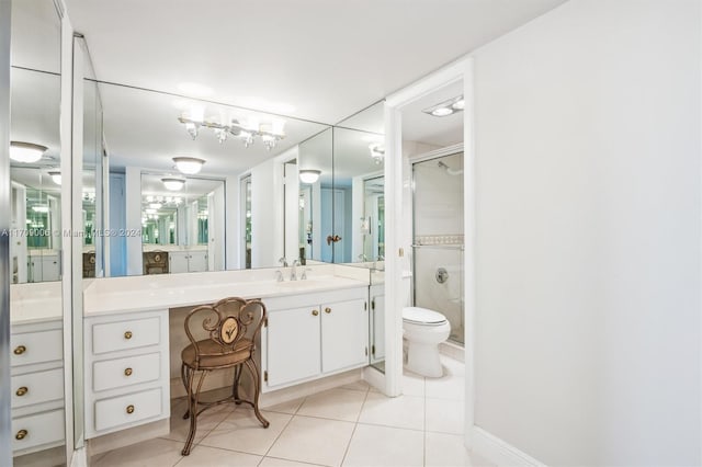 bathroom with tile patterned flooring, vanity, toilet, and an enclosed shower