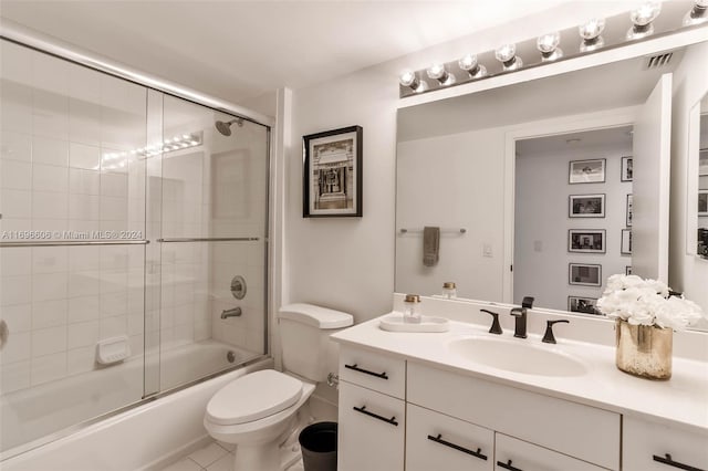 full bathroom with shower / bath combination with glass door, tile patterned flooring, vanity, and toilet