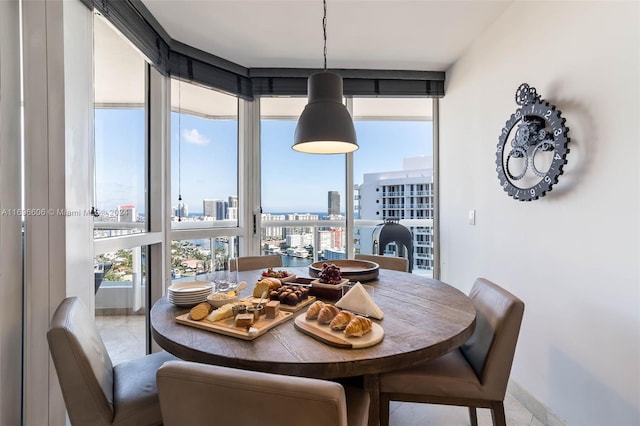 dining space featuring expansive windows and light tile patterned flooring