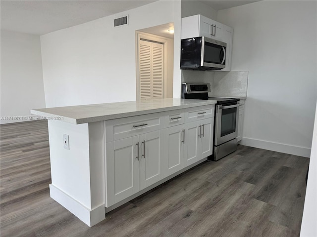 kitchen featuring white cabinetry, kitchen peninsula, appliances with stainless steel finishes, and dark wood-type flooring