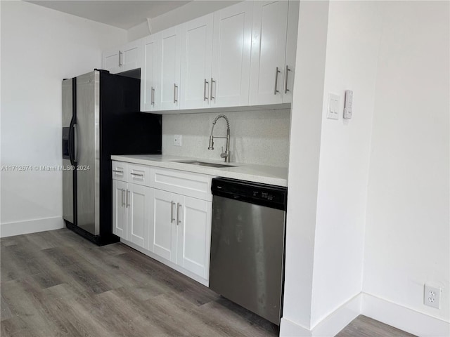 kitchen with white cabinetry, sink, stainless steel appliances, wood-type flooring, and decorative backsplash