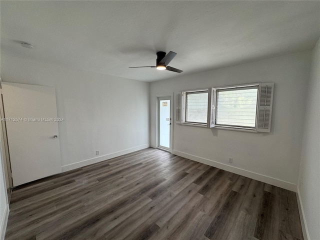 spare room featuring ceiling fan and dark wood-type flooring