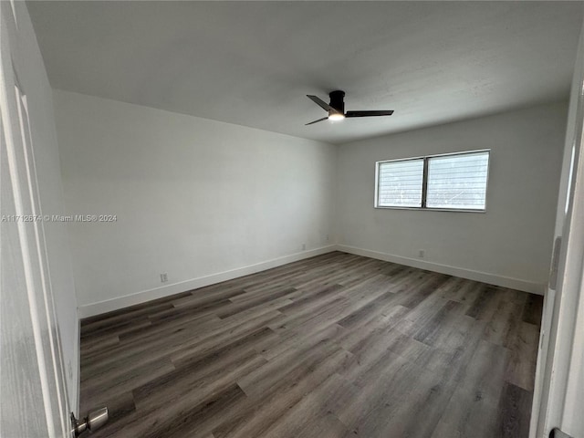 empty room with dark hardwood / wood-style floors and ceiling fan