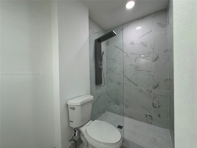 bathroom featuring a tile shower and toilet