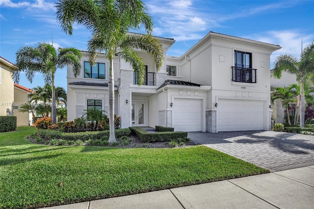 view of front of home with a garage, a balcony, and a front yard