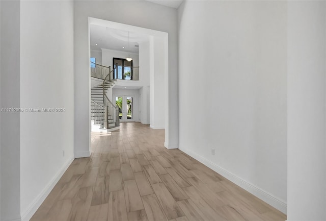 hallway featuring a high ceiling and light wood-type flooring