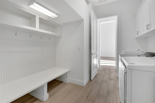 mudroom with light hardwood / wood-style floors, washer / dryer, and sink