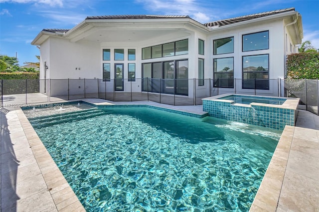 view of swimming pool with pool water feature and an in ground hot tub