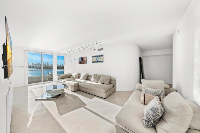 tiled living room with a water view and track lighting