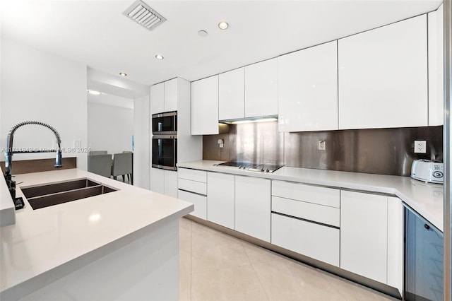 kitchen featuring black electric stovetop, white cabinetry, and sink