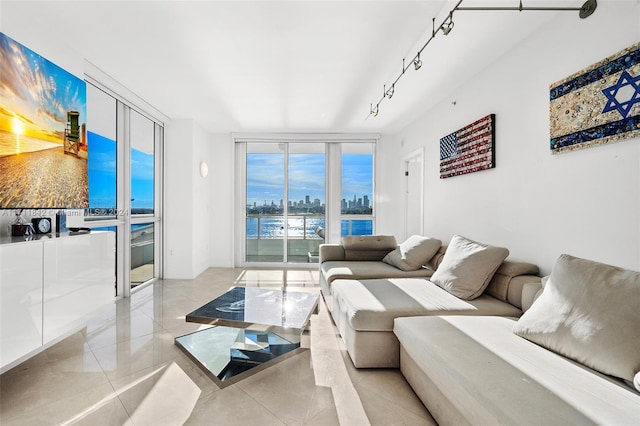 tiled living room featuring a water view, expansive windows, and rail lighting