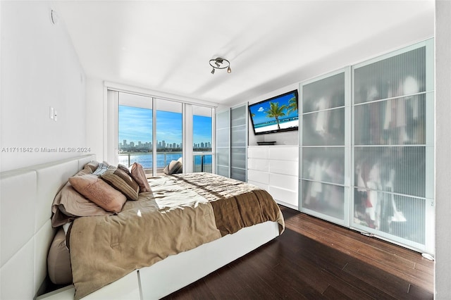 bedroom featuring dark hardwood / wood-style flooring and expansive windows