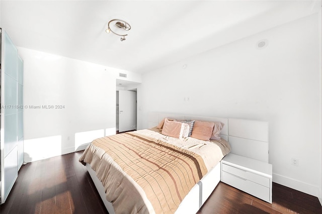 bedroom with dark wood-type flooring