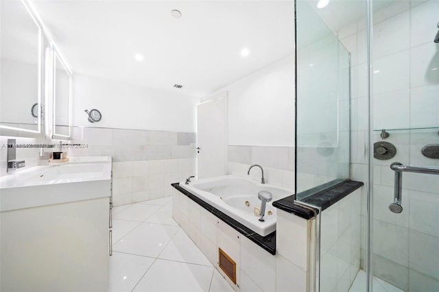 bathroom with tile patterned floors, vanity, and shower with separate bathtub