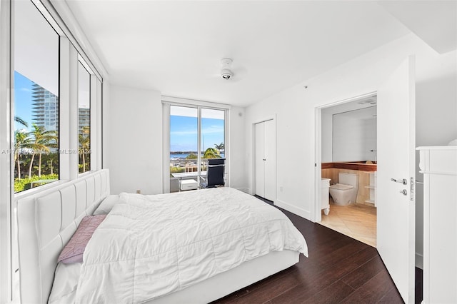 bedroom with dark hardwood / wood-style floors, ensuite bath, and multiple windows