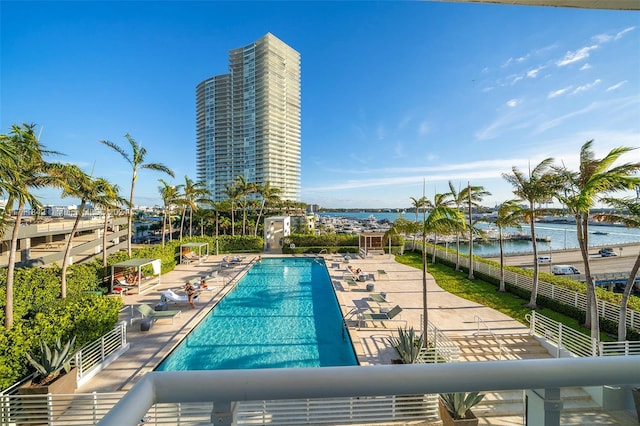 view of swimming pool with a patio area and a water view