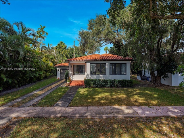 mediterranean / spanish-style house with a garage and a front yard