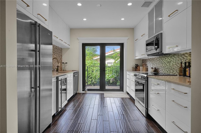 kitchen with french doors, sink, appliances with stainless steel finishes, beverage cooler, and white cabinets