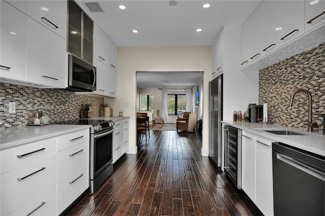 kitchen featuring dark wood-type flooring, appliances with stainless steel finishes, sink, and white cabinets