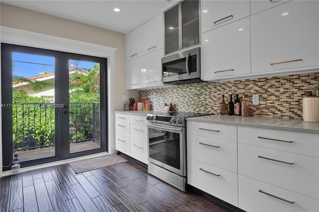 kitchen with stainless steel appliances, tasteful backsplash, white cabinets, and french doors