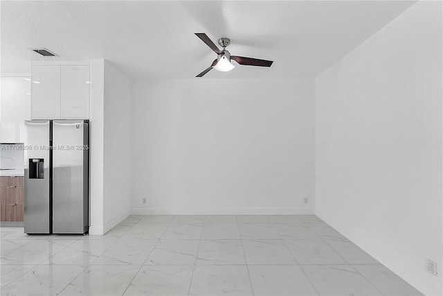 empty room featuring ceiling fan and a textured ceiling