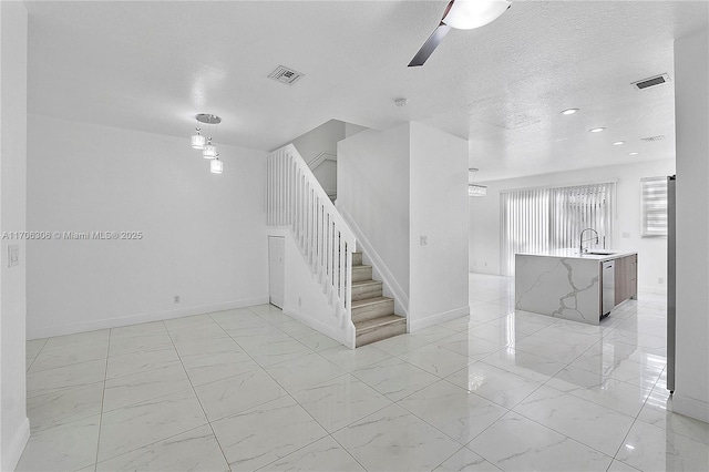 staircase featuring ceiling fan and sink