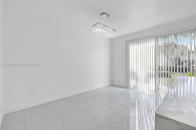 empty room with a notable chandelier and a textured ceiling