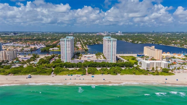 drone / aerial view with a water view, a city view, and a beach view