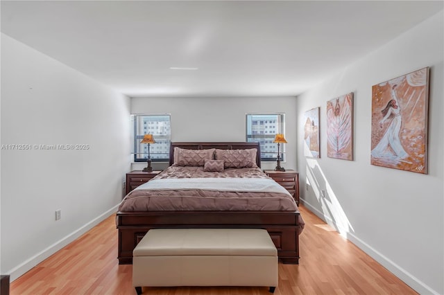 bedroom featuring light wood finished floors and baseboards