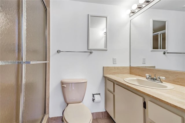 full bathroom featuring a shower with door, toilet, and vanity